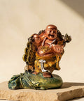 Rust-colored Joy Buddha statue from House of Mandana, a Zen decor piece with serene expression and intricate detailing.